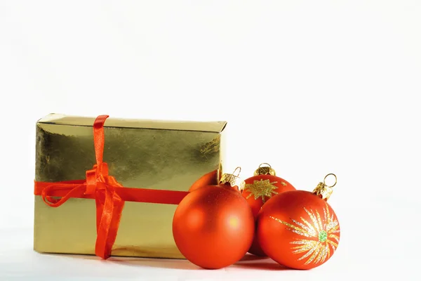 Palle di Natale rosse e una confezione regalo — Foto Stock