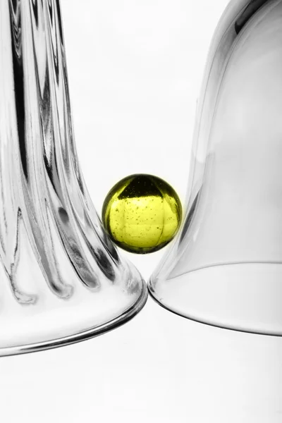 Um copo de vinho, um vaso de vidro e uma bola amarela — Fotografia de Stock