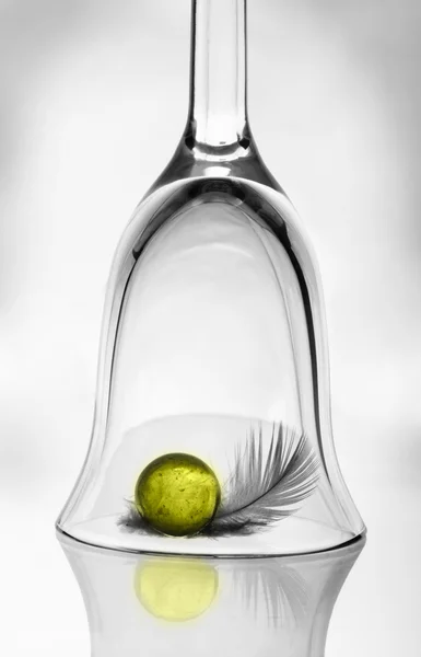 Um copo de vinho, uma bola amarela e uma pena — Fotografia de Stock