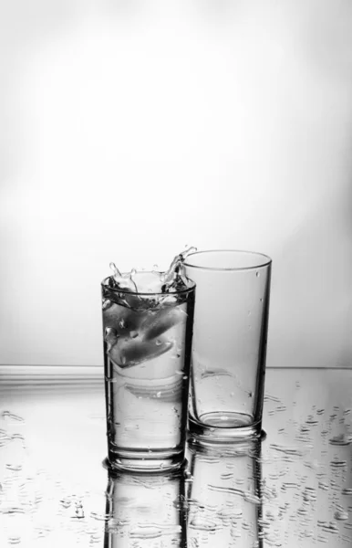 Deux verres, des morceaux de glace et des gouttes d'eau — Photo