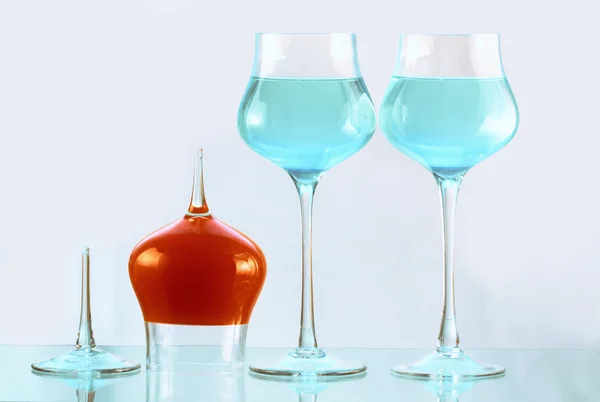 Due bicchieri da vino con acqua blu e uno con acqua arancione — Foto Stock