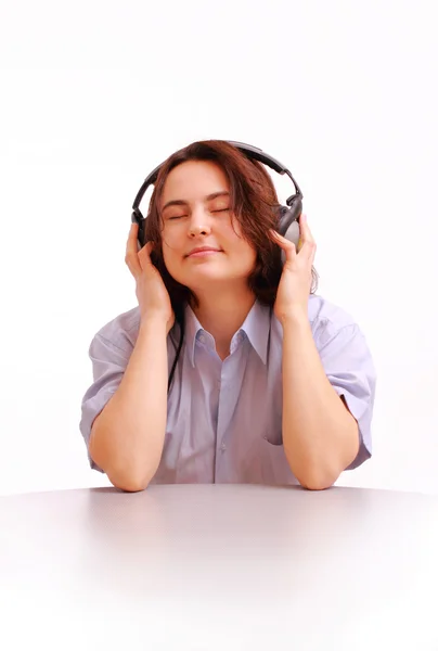 A young girl listens to the music on headphones — Stock Photo, Image