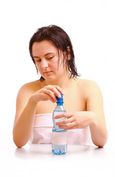 Uma jovem abre uma garrafa de água mineral — Fotografia de Stock