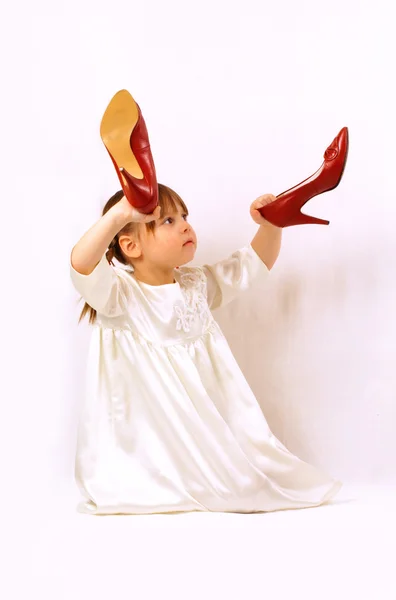 A little girl holds big shoes — Stock Photo, Image