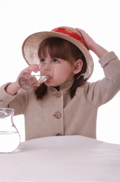 A little girl drinks water from a glass — Stock Photo, Image