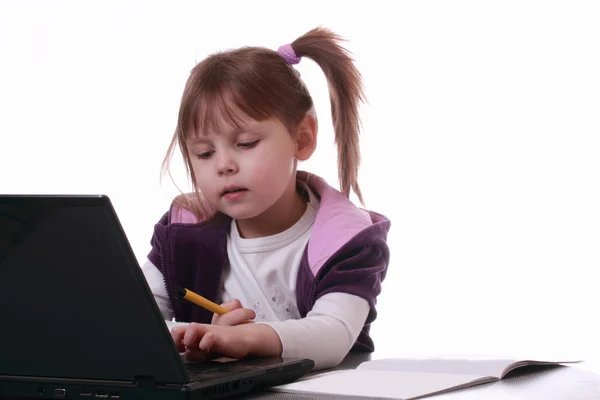 一个小女孩正在用一台笔记本电脑 — 图库照片