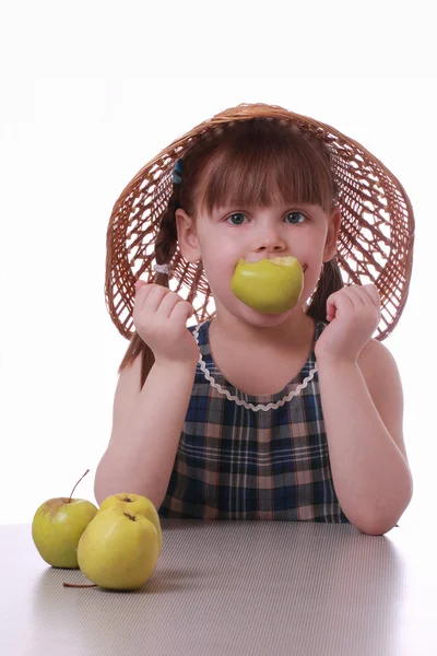 A little girl with an apple in the mouth — Stock Photo, Image