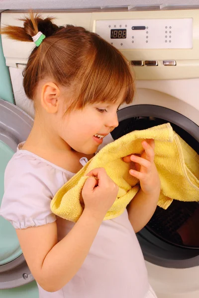Uma menina está segurando uma toalha após a lavagem — Fotografia de Stock