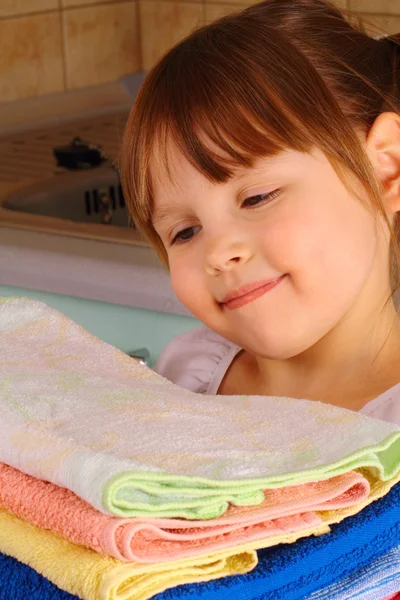 Egy kislány csodálja a törölköző mosás után Jogdíjmentes Stock Képek
