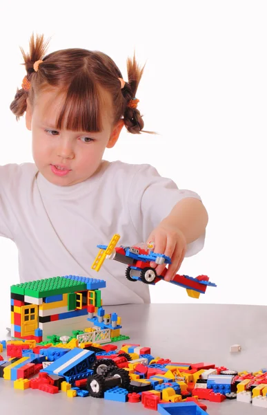 Liten flicka spelar ett spel med en leksak flygplan — Stockfoto