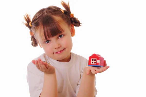 A kislány egy kulccsal és egy házat a kezében Stock Kép