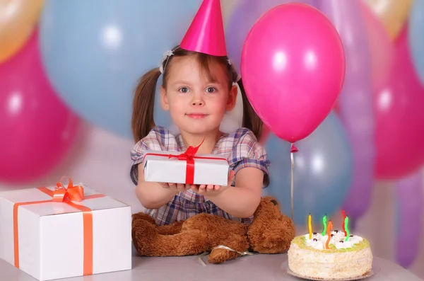 Happy little girl holds a gift on her Birthday — Stock Photo, Image