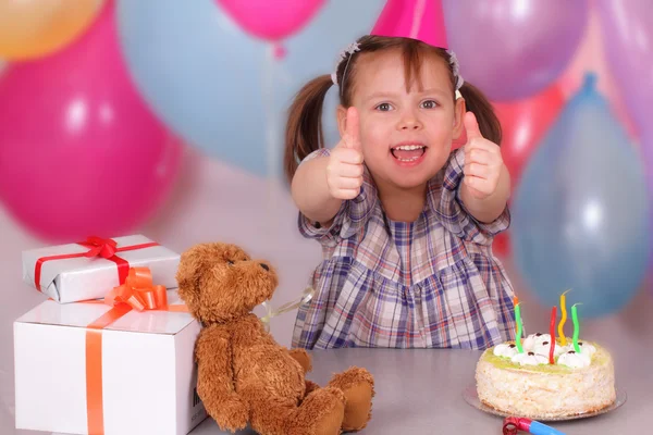 Niña sonriente con sus regalos en el cumpleaños — Foto de Stock