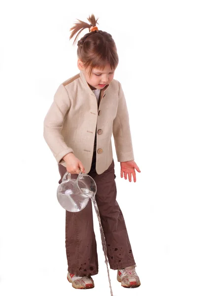 Klein meisje giet water uit een kruik — Stockfoto