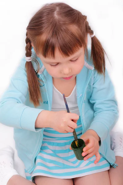 Kleines Mädchen rührt mit Pinsel die Farbe an — Stockfoto
