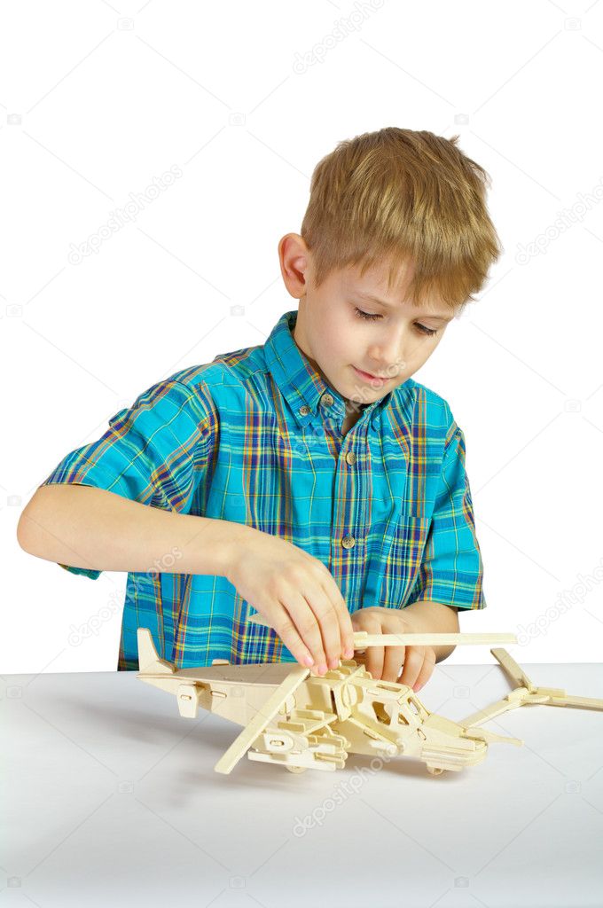 A boy builds a wooden helicopter