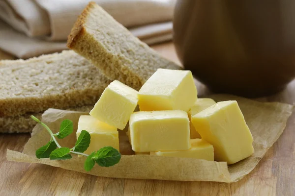 Verse gele boter op een houten tafel — Stockfoto