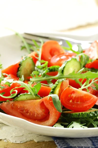Свежий салат из рукколы с помидорами, огурцы в белой тарелке — стоковое фото