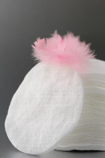 Esponjas de discos cosméticos de algodón con una pluma rosa —  Fotos de Stock