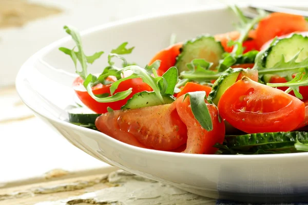 Ensalada de rúcula fresca con tomates, pepinos en un plato blanco —  Fotos de Stock