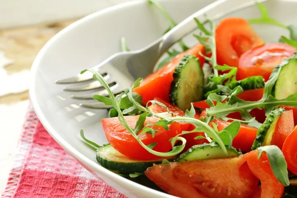 Ensalada de rúcula fresca con tomates, pepinos en un plato blanco —  Fotos de Stock