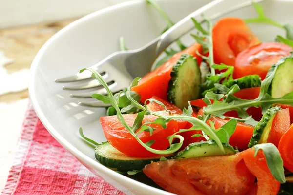 Salada de arugula fresca com tomates, pepinos em uma chapa branca — Fotografia de Stock