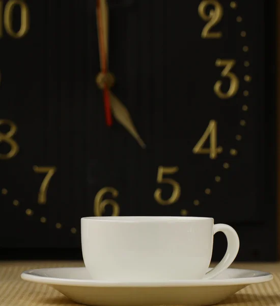 Tasse Tee auf dem Hintergrund der Uhr das Konzept der 5 Uhr — Stockfoto