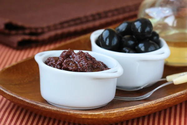 Appetizer of olives, tapenade on a wooden board — Stock Photo, Image