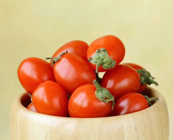 Small cherry tomatoes in a wooden bowl — Stock Photo, Image