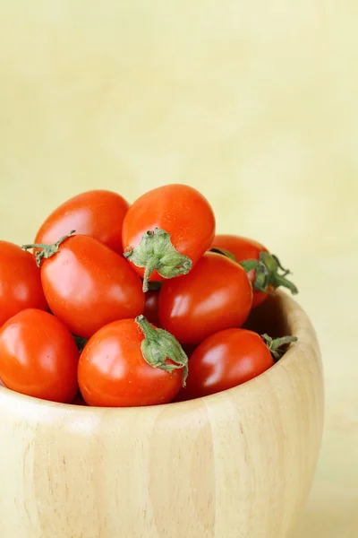 Small cherry tomatoes in a wooden bowl — Stock Photo, Image