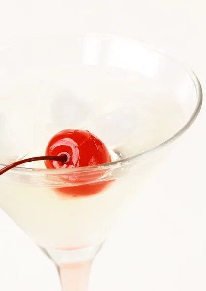 Мартини с красной вишней в стакане на белом фоне — стоковое фото
