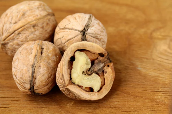 Chopped and whole walnuts on a brown background — Stock Photo, Image