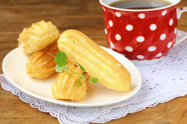 Cake eclair profiteroles on a plate clipart