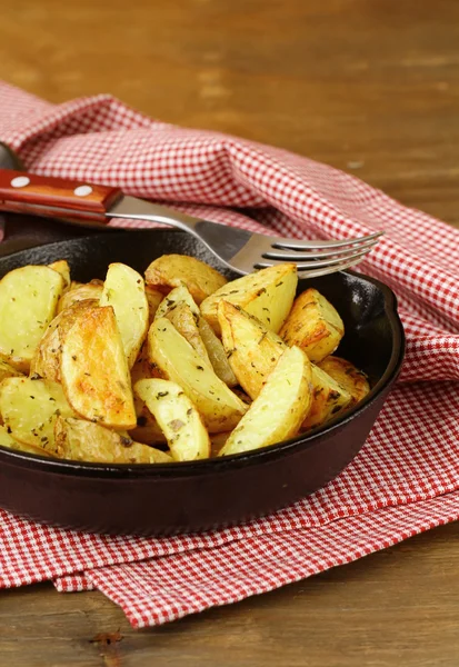 Fresh potatoes fried in a pan on a wooden table — Stock Photo, Image