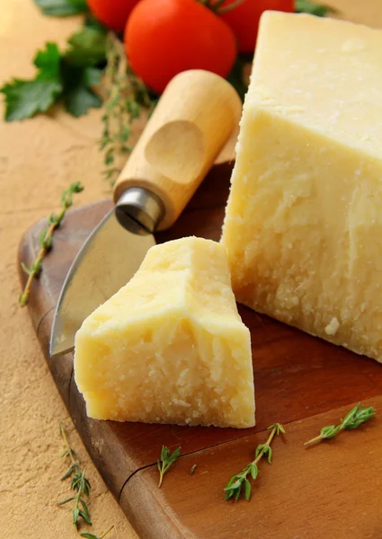 Sýr parmazán na dřevěné desce s rajčaty — Stock fotografie