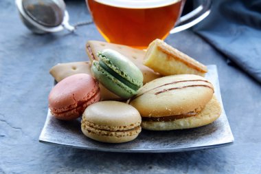 arka planda çay seti ile geleneksel Fransız macarons