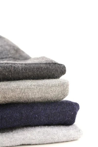 Куча тёплых вязаных серых свитеров — стоковое фото