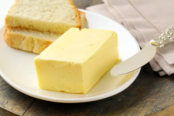 एक लकड़ी के स्टैंड पर ताजा पीला मक्खन, कार्बनिक उत्पाद — स्टॉक फ़ोटो, इमेज
