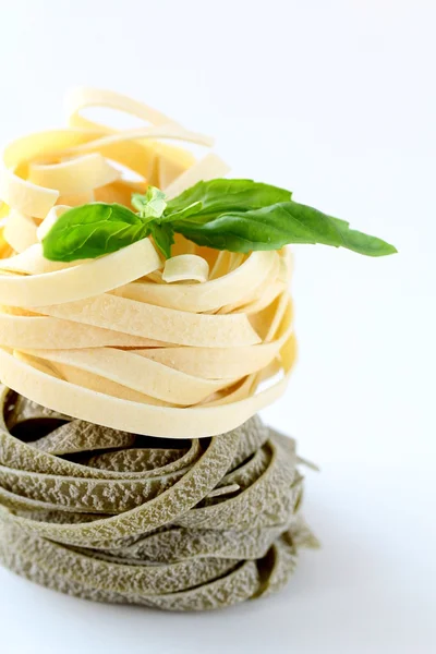 Stock image Italian pasta fettuccine nest with basil