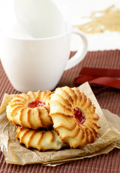 Schöne Kekse mit Marmelade auf braunem Hintergrund — Stockfoto