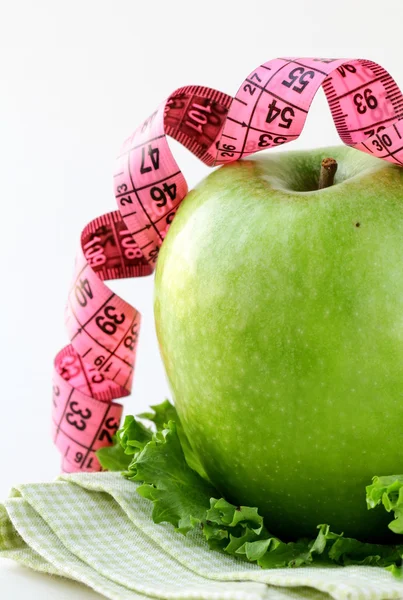 Diet concept Ripe green apple with measuring tape — Stock Photo, Image