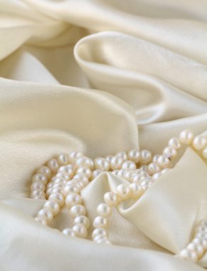 Pearls a necklace on a silk fabric clipart