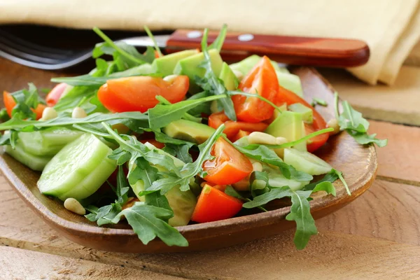 roka ve ahşap bir tabakta domates salatası