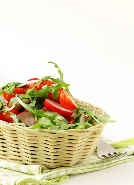 Salad with arugula and cherry tomatoes on a wooden plate — Stock Photo, Image