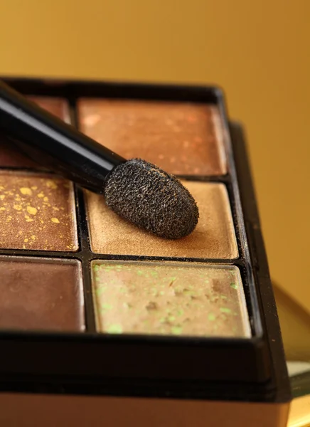 Gold eyeshadow palette with a brush — Stock Photo, Image