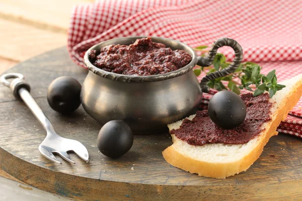 Appetizer of olives, tapenade on a wooden board — Stock Photo, Image