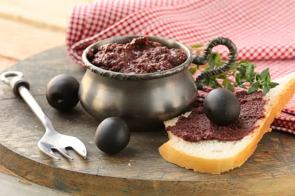 stock image Appetizer of olives, tapenade on a wooden board