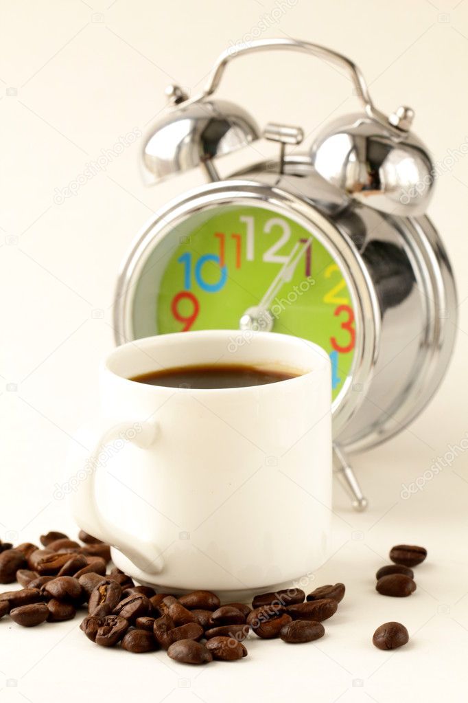 Alarm clock and white coffee cup
