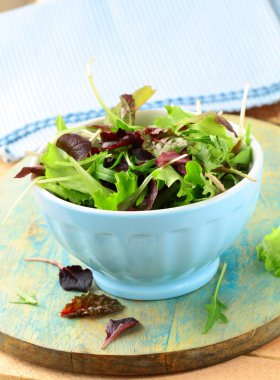 Mix salad (arugula, iceberg, red beet) in a bowl on the table clipart