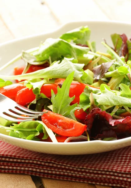 Salat (Rucola, Eisberg, Rote Bete) in einer Schüssel auf dem Tisch mischen — Stockfoto